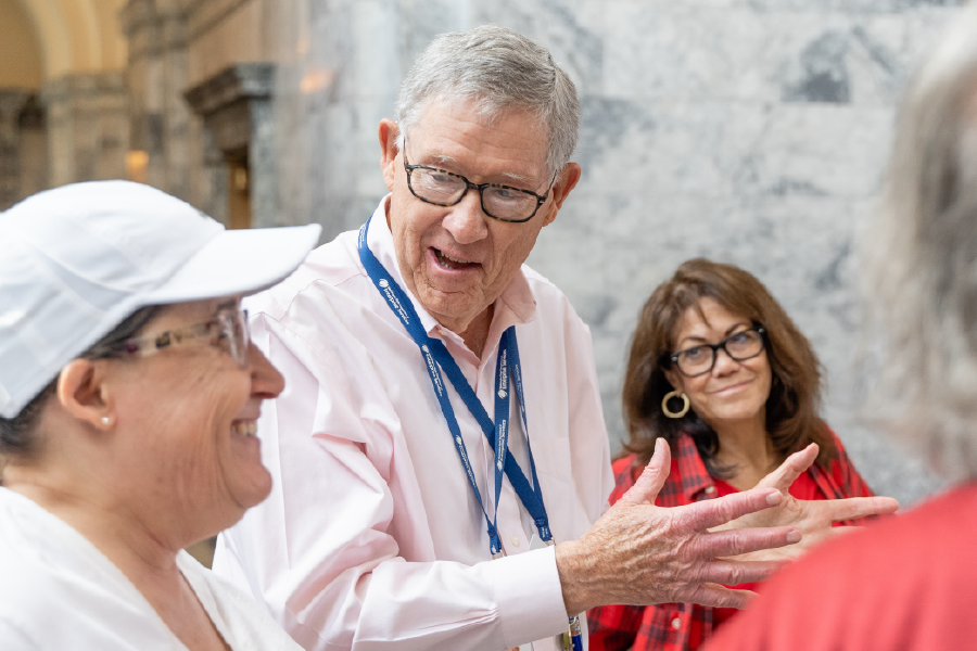 A group of tour participants listen intently as a Washington state tour guide leads them through the Legislative Building.