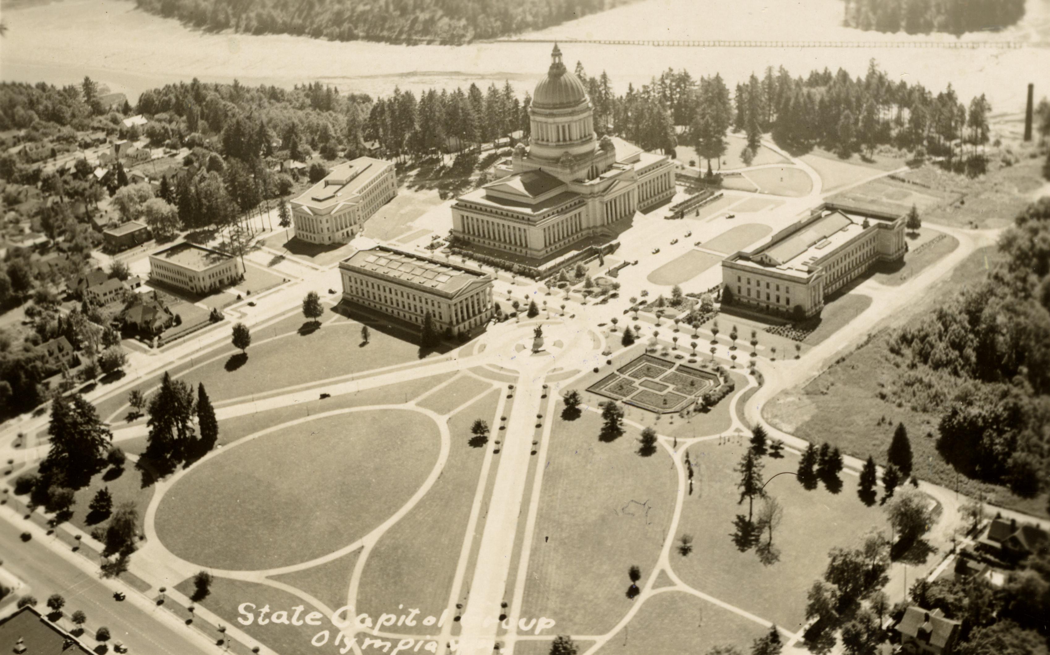 A historical photo of the Capitol Campus from an aerial view, highlighting the original buildings and landscape.