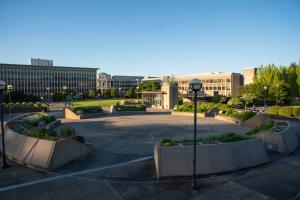 A wide shot showing the entire Pollinator Garden with the East Campus lawn, Highways and Licenses Building, Natural Resources Building, and Office Building 2 in the background.