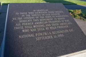 A close-up highlighting the text inscribed in the Prisoner of War-Missing in Action Memorial's granite top.