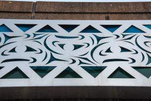 A close-up of one of the Sea to Sky mural's panels, showcasing the intricate pattern cut into the steel that reveals the colored glass behind it. 