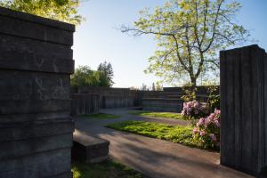 Concrete walls enclose beautiful purple flowers, cement pathways, and trees in the Water Garden. 