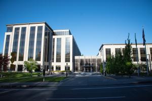 A wide shot highlighting the landscaping around the 1500 Jefferson building, consisting of trees, grass, flagpoles, and light poles.