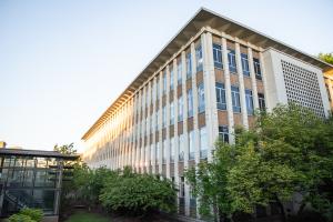 A view of the back corner of the Employment Security Department Building from the northwest. The back of the building is lined with green trees, and there is a stairway leading to the Plaza Garage parking lot.