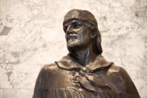 A close-up of the upper portion of the bronze Marcus Whitman statue. The statue depicts Whitman wearing a fur cap and a cloth tied around his neck.