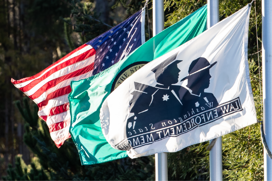 The United States, Washington State, and Behind the Badge Foundation (the Washington State Law Enforcement Memorial Foundation) flags are flown at the top of the Law Enforcement memorial..