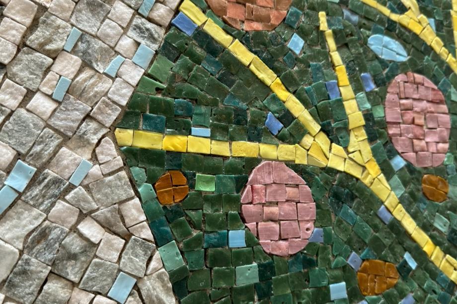 A closeup picture of the tiny glass and stone pieces that make up a mosaic.