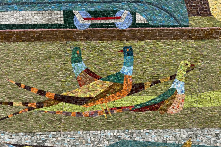 A colorful glass and stone mosaic depicting a group of birds walking on grass.