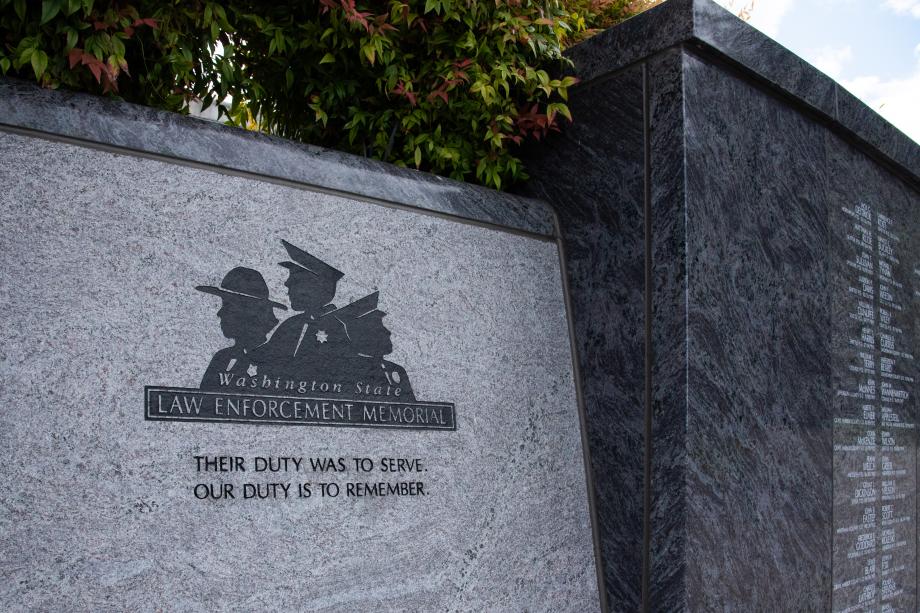 A close-up of the Law Enforcement Memorial logo etched into a cement wall in black above the following text: "Their duty was to serve. Our duty is to remember."