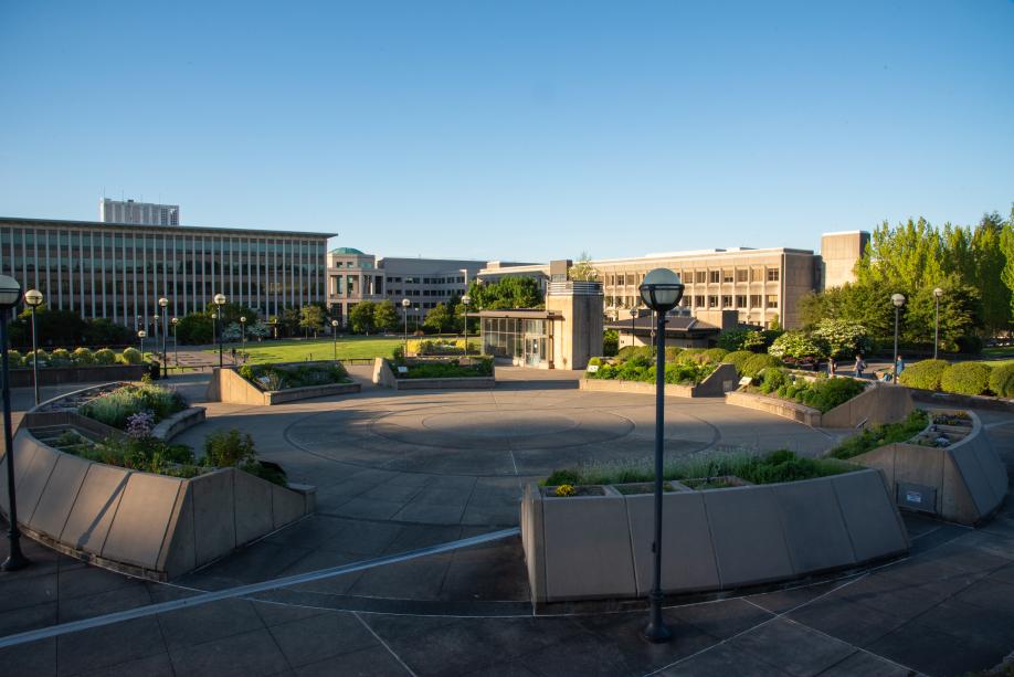 A wide shot showing the entire Pollinator Garden with the East Campus lawn, Highways and Licenses Building, Natural Resources Building, and Office Building 2 in the background.