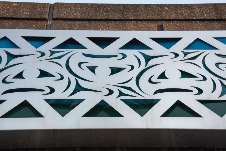 A close-up of one of the Sea to Sky mural's panels, showcasing the intricate pattern cut into the steel that reveals the colored glass behind it. 