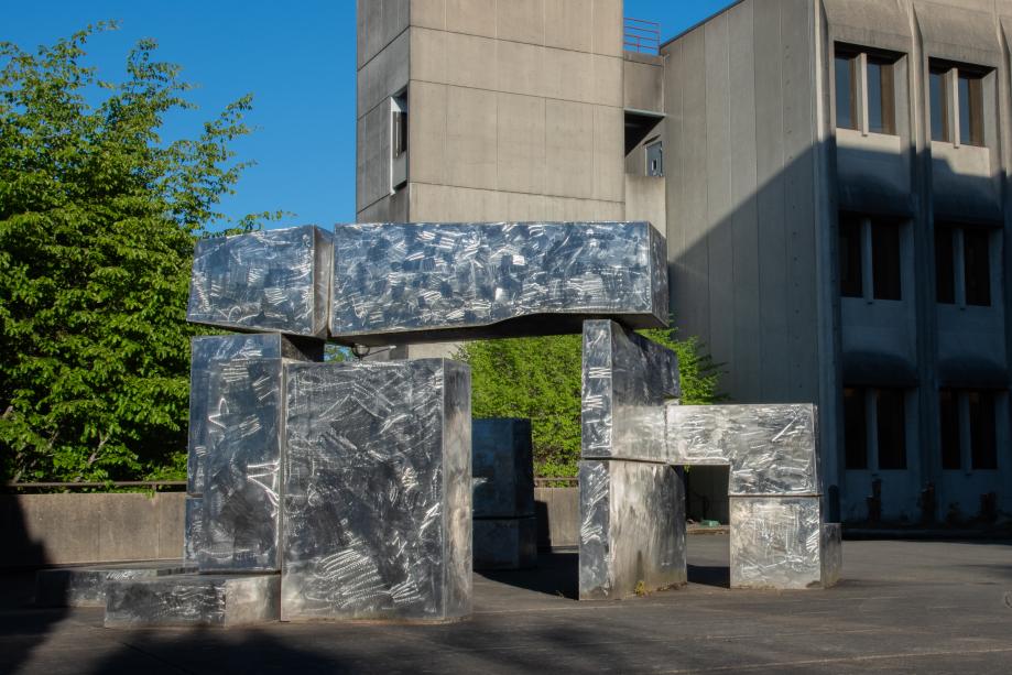 The square edges of the Untitled Stainless Steel Statue mimic the square shapes of the Department of Transportation Building next to it.