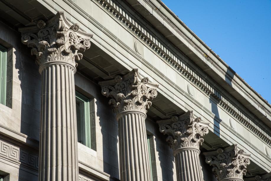 A close up shot of the Dolliver Building's Greek-style columns made of sandstone. Each column is topped with a sandstone crown with intricate designs carved into it.