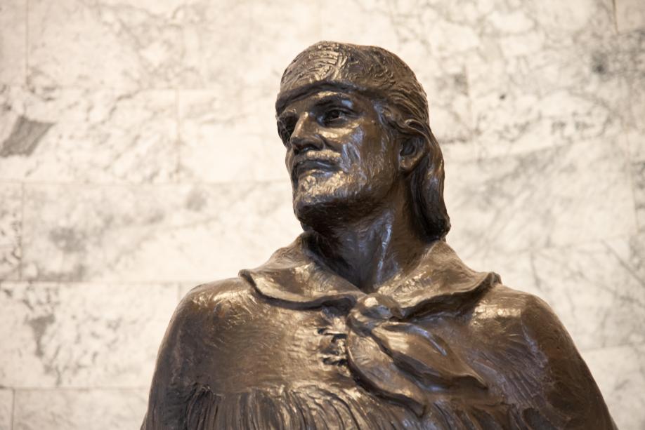 A close-up of the upper portion of the bronze Marcus Whitman statue. The statue depicts Whitman wearing a fur cap and a cloth tied around his neck.