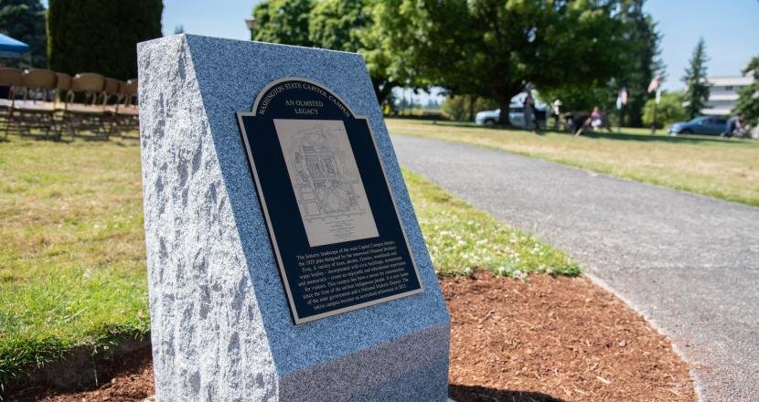 The Olmsted Legacy Marker, a detailed bronze plaque set in a granite pedestal, stands near the center the West Campus lawn between the Medal of Honor Memorial and Tivoli Fountain.