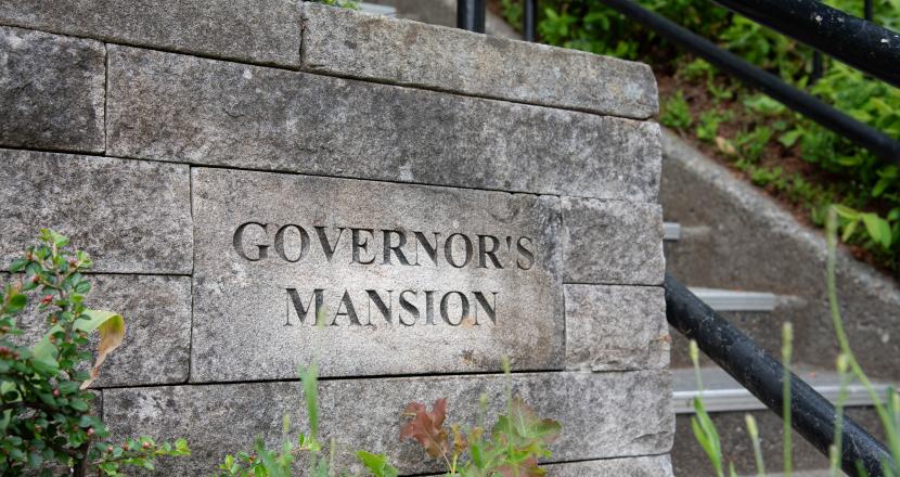 The words "Governor's Mansion" inscribed on a rock wall outside the steps leading to the building on the Washington State Capitol Campus.