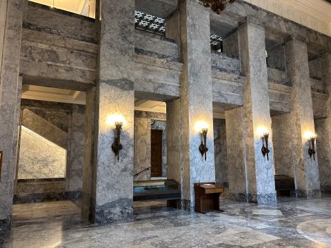 The marble interior of the Temple of Justice's main lobby. Four square columns are decorated with classical style lanterns.