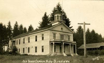 A black and white image of the Washington Territorial Capitol Building, which was a small white building with a little tower on the roof. Words at the bottom of the image read "Old State Capitol Bldg. Olympia, WN."