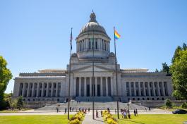 The North side of the Capitol Building with the Flag Circle in the foreground with a blue sky background.