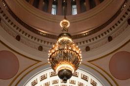 A wide, low angle shot of a giant chandelier hanging from the Legislative Building rotunda.