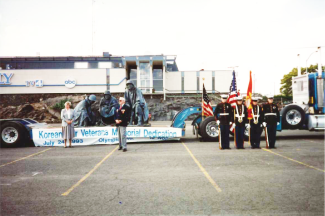A photo of a bronze statue atop a flatbed truck.