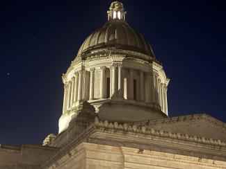 The Legislative Building’s dome at night prior to lighting repair work. The dome is dimly lit and the area surrounding it is dark.