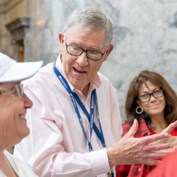 A group of tour participants listen intently as a Washington state tour guide leads them through the Legislative Building.