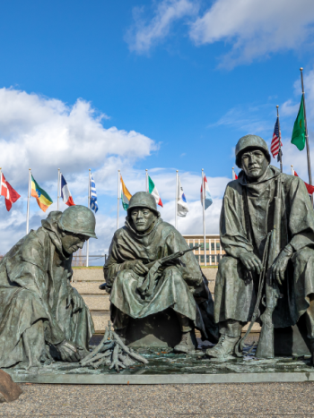 The Korean War memorial features three bronze statues of soldiers huddling around a fire, with 22 flags, representing each of the nations that joined the U.S in the war effort.