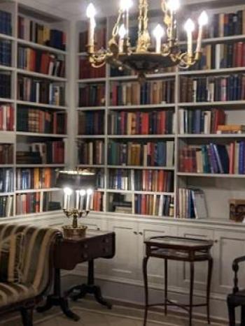 The library in the Governor's mansion, which has shelves lined with books and a chandelier hanging from the ceiling.