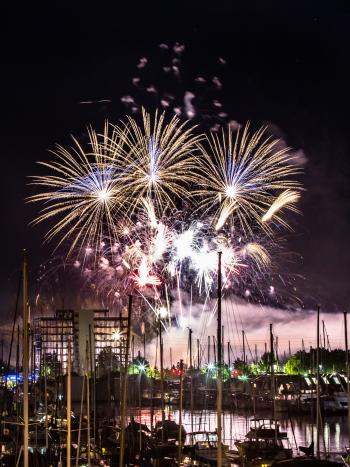 Fireworks explode in the night sky over Capitol Lake as part of the annual Lakefair event