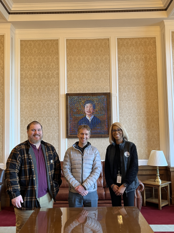 Three people smiling for a photo inside the Temple of Justice