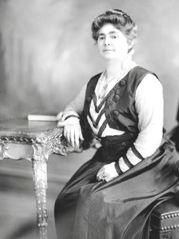 Portrait of Mary Alma Thornton Lister sitting at a desk in a dress.