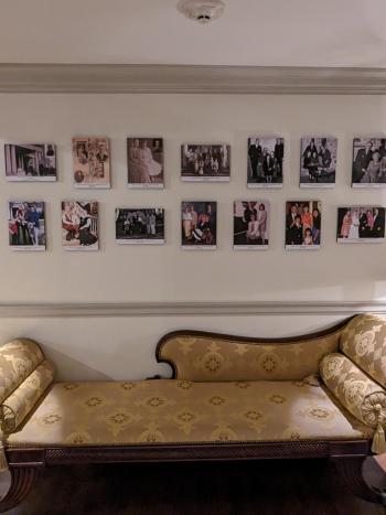 The hallway inside of the Governor's Mansion where portraits of past Governors are hung on a white wall.