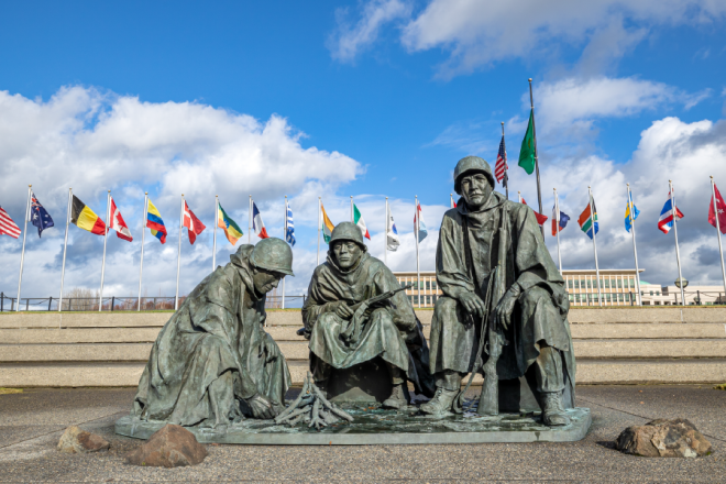 The Korean War memorial features three bronze statues of soldiers huddling around a fire, with 22 flags, representing each of the nations that joined the U.S in the war effort.