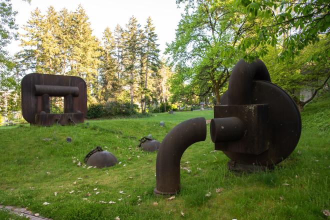 A wide shot of the Boiler Works statue with trees in the background. 