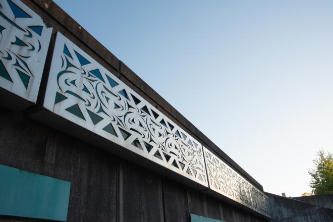 A low-angle shot of the Sea to Sky mural with a light blue sky in the background.