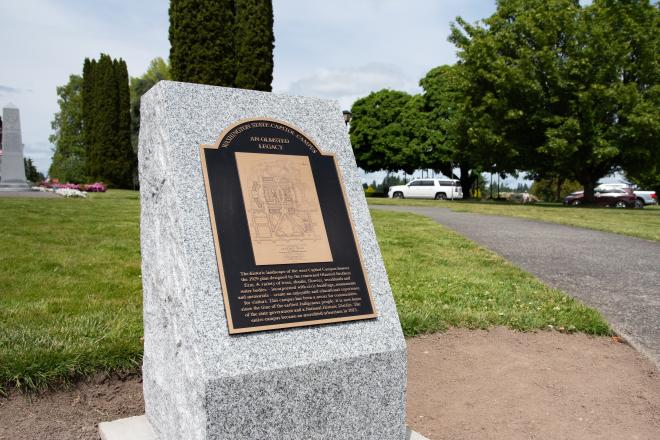 The Olmsted Legacy Marker, a detailed bronze plaque set in a granite pedestal, stands near the center the West Campus lawn between the Medal of Honor Memorial and Tivoli Fountain.